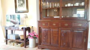 une grande armoire en bois dans une pièce avec une table dans l'établissement Gutshaus von Bülow - 19-01, à Kägsdorf