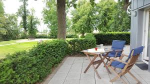 - un patio avec 2 chaises et une table dans l'établissement Gutshaus von Bülow - 19-01, à Kägsdorf