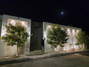 a man standing on the side of a building with his hand up at منتجع آركو ARCO Resort in Al Wudayy