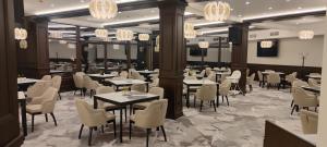 a dining room with tables and chairs and chandeliers at Spa Hotel Armira in Starozagorski Bani