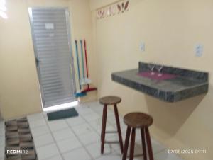a bathroom with two stools and a counter with a sink at kitnet A in São Luís