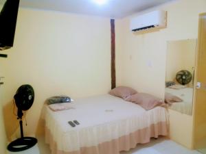 a small room with a bed and a fan at kitnet A in São Luís