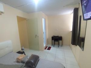 a room with a couch and a television and a table at kitnet A in São Luís