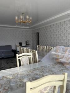 a dining room with a table and chairs and a chandelier at Don-Talaa Guest House in Döng-Talaa