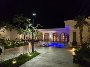 a house with a swimming pool at night at منتجع آركو ARCO Resort in Al Wudayy