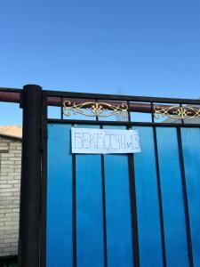 a white sign on a gate with a blue wall at Don-Talaa Guest House in Döng-Talaa +12 photos