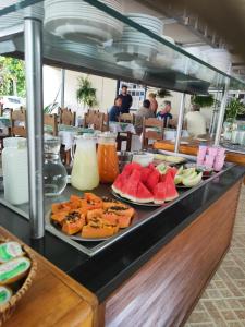 a buffet line with plates of fruit and juice at 4 Ventos Pousada in Paraty