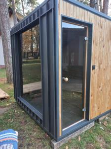 een containerwoning met een deur in het gras bij Żuraw in Bocheniec +3 foto's