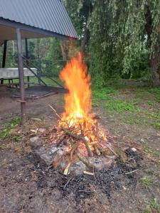 Er brandt een vuur in een veld met een bankje. bij Żuraw in Bocheniec
