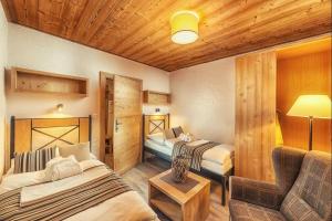 a hotel room with two beds and a couch at Chalets Jasná Centrum APARTMENT M - Free Jacuzzi & Sauna and Chopok view in Belá