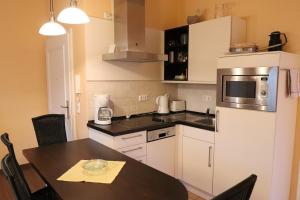 een kleine keuken met een tafel en een magnetron bij Dünenschloss - 02-29 in Kühlungsborn