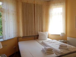 een slaapkamer met een bed met handdoeken erop bij Dünenschloss - 02-29 in Kühlungsborn +11 foto's