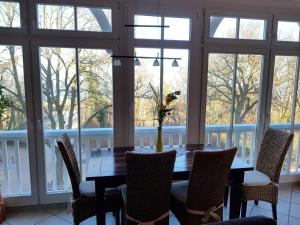 een eettafel met stoelen en een vaas met bloemen bij Dünenschloss - 02-27 in Kühlungsborn
