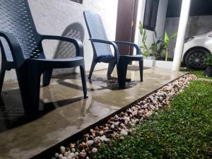 two chairs sitting on a patio with rocks at Seven S villa in Kamburugamuwa