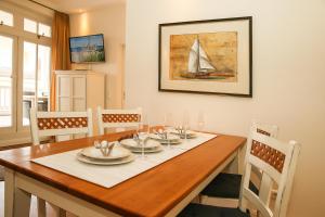 een eetkamer met een tafel en een zeilboot aan de muur bij Dünenschloss - 02-24 in Kühlungsborn