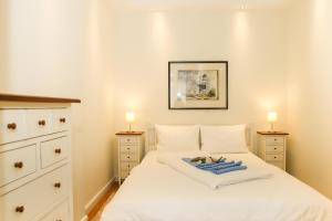 een slaapkamer met een wit bed en 2 nachtkastjes bij Dünenschloss - 02-24 in Kühlungsborn