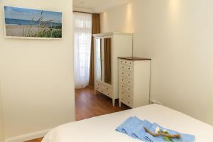 een slaapkamer met een bed, een ladekast en een spiegel bij Dünenschloss - 02-24 in Kühlungsborn +8 foto's