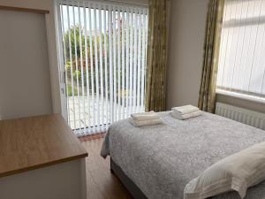 a bedroom with a bed and a large window at The Knutsford Bungalow in Knutsford