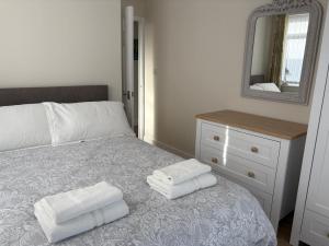 a bedroom with a bed with two towels on it at The Knutsford Bungalow in Knutsford