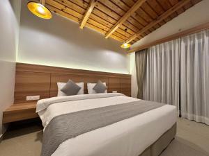 une chambre avec un grand lit dans une pièce dans l'établissement Angel Pink Resort With A River Access - Mukhteshwar, à Nainital