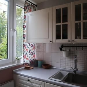 a kitchen with white cabinets and a sink and a window at Wygodne mieszkanie dla dwojga in Bystrzyca Kłodzka