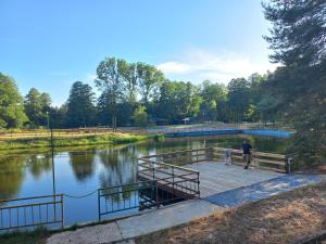 een man op een steiger naast een meer bij Czapla in Bocheniec