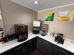 a kitchen with two video game machines on a counter at Quality Inn Ormond Beach - Daytona in Ormond Beach +43 photos