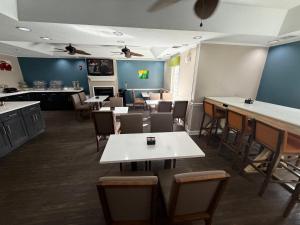 a restaurant with tables and chairs and a kitchen at Quality Inn Ormond Beach - Daytona in Ormond Beach +46 photos