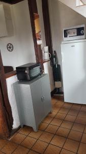 a microwave sitting on top of a refrigerator at LA Chataigne in Santranges +4 photos