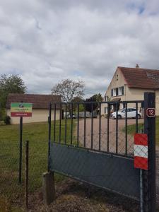 a gate in front of a building with a parking lot at LA Chataigne in Santranges