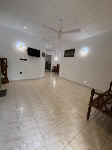 a large room with a white wall and a television at Villa By Dissa in Dikwella North