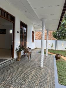a porch of a house with a bench and columns at Villa By Dissa in Dikwella North