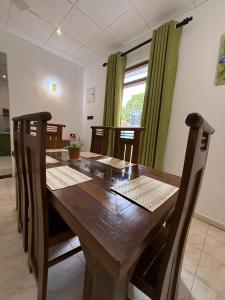 a wooden dining room table with chairs and a window at Villa By Dissa in Dikwella North