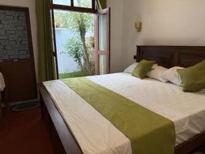 a bedroom with a large bed with a window at Villa By Dissa in Dikwella North