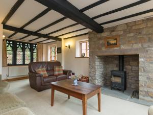 een woonkamer met een bank en een open haard bij Parkers in Mathon