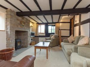 een woonkamer met een bank en een open haard bij Parkers in Mathon