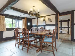 een eetkamer met een houten tafel en stoelen bij Parkers in Mathon