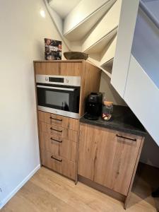a kitchen with a microwave in a wooden cabinet at B&B Mirre in Kapelle