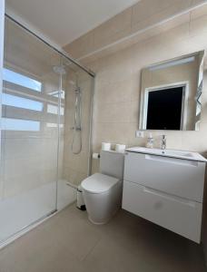 a bathroom with a toilet and a shower and a sink at Gloria's House in Lagoa