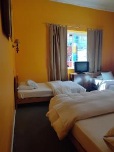een hotelkamer met 3 bedden en een raam bij De Gino Hostal in El Cerrillo