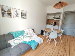 een woonkamer met een bank en een tafel bij La lueur boréale in Belfort