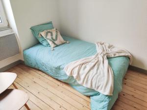 een klein bed in een hoek van een kamer bij La lueur boréale in Belfort