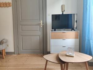 een woonkamer met een tv en een tafel bij La lueur boréale in Belfort