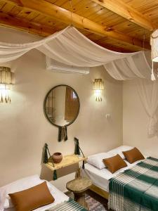 a bedroom with two beds and a mirror at Timber House Dahab in Dahab