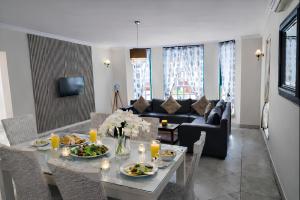 a living room with a table with food on it at The Villa Manor & Spa Exclusive Escape in Bela-Bela