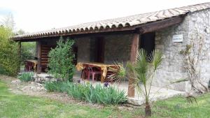 a stone cottage with a wooden table in front of it at Mirabel #2, Maisonette, terrace and pool access in Grospierres +4 photos