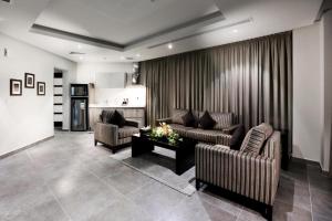 a living room with two couches and a table at سدو بوتيك الخبر in Al Khobar