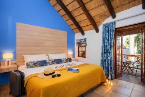 een slaapkamer met een bed met een hoed erop bij The Villa Manor & Spa Exclusive Escape in Bela-Bela +102 foto's