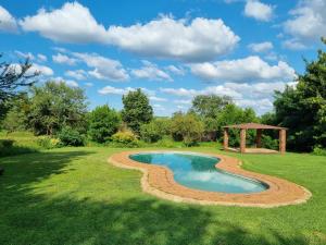 a pool in a yard with a gazebo at Patrys Paradys in Maanhaarrand