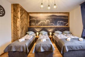 two beds in a room with a painting on the wall at Chata u Bożeny in Muszyna +133 photos